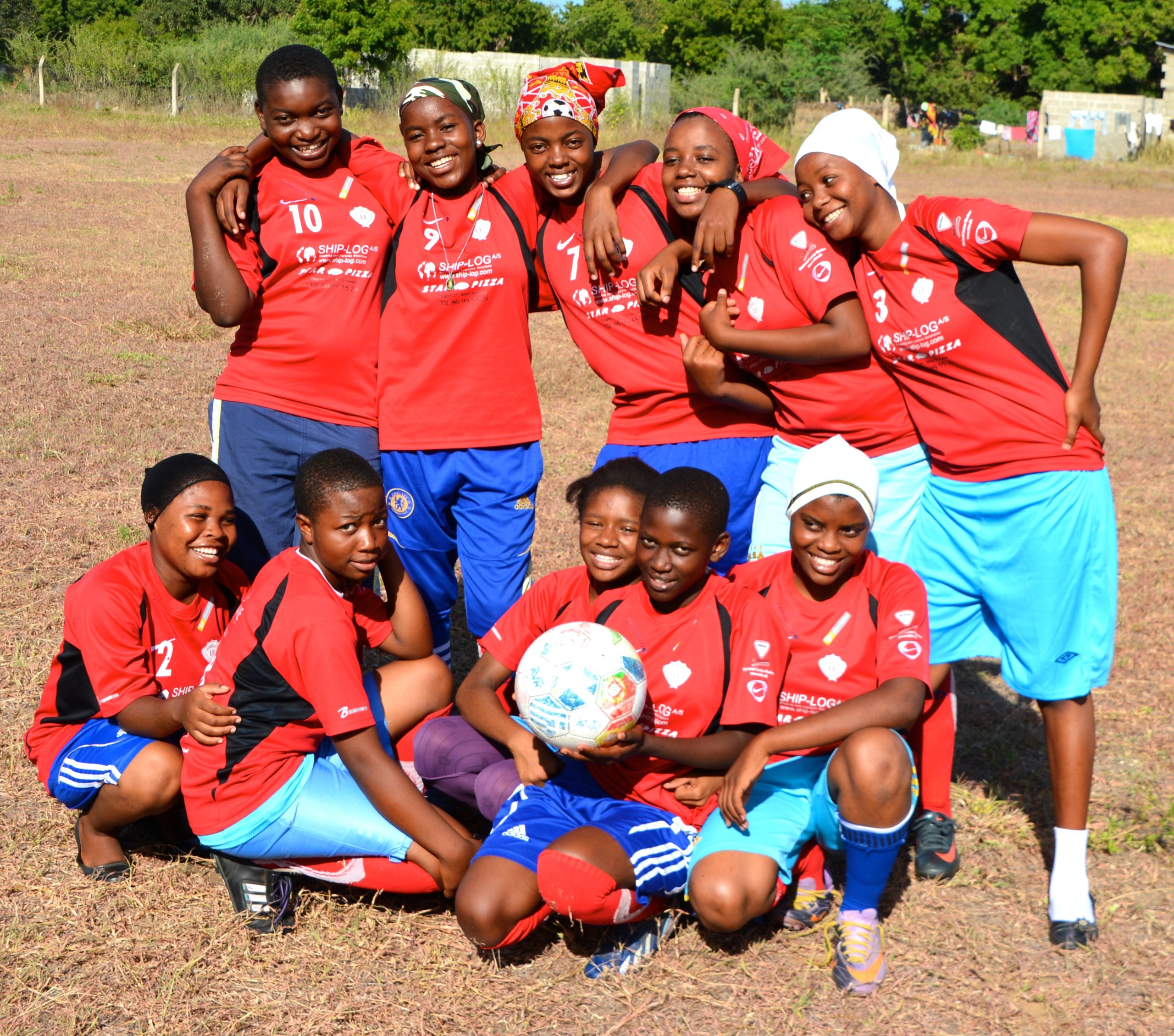 2014 students pose with a soccer ball on a field outside